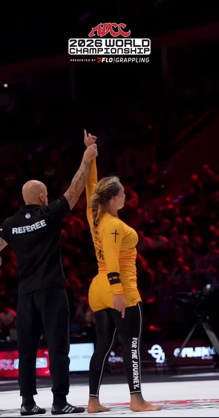 Paige Ivette Clymer, in a yellow rash guard, has her arm raised by the referee on the ADCC 2026 World Championship mat